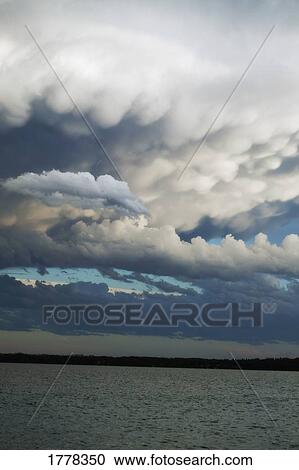 Stock Image - Dark clouds over water. Fotosearch