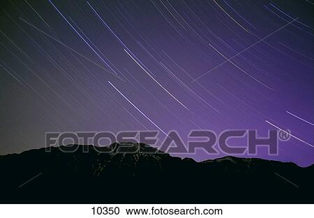 Stock Image - Star trails in night's sky. Fotosearch