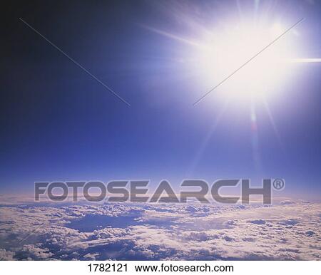 Stock Image - Sun shining over the clouds. Fotosearch