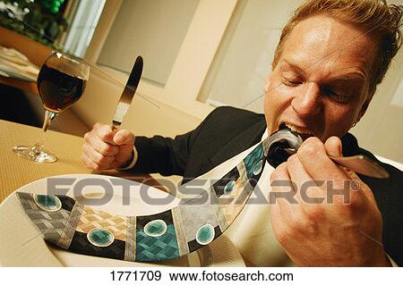 Businessman eating his necktie View Large Photo Image Stock Photo - Businessman eating his necktie. Fotosearch
