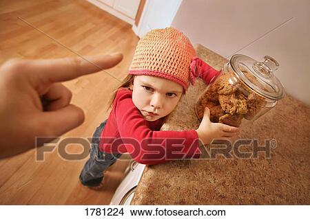 Picture - Child gets in trouble for sneaking cookies. Fotosearch