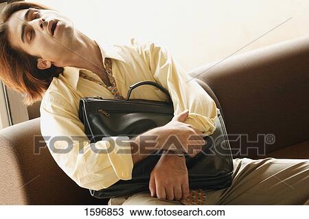 Stock Image - Man dozes in airport. Fotosearch