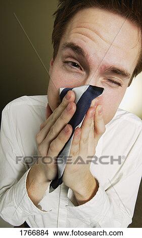 Picture - Man sneezes into tie. Fotosearch