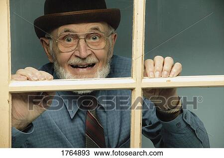 Stock Image - Senior looks out window. Fotosearch