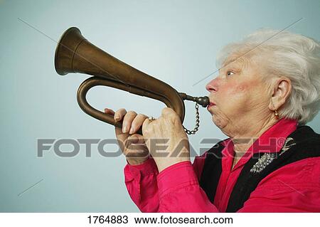 Stock Image - Woman plays horn. Fotosearch
