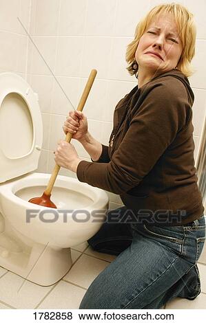 Woman plunging the toilet View Large Photo Image Stock Photo - Woman plunging the toilet. Fotosearch