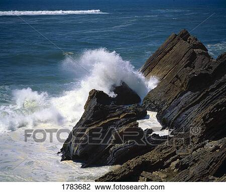 Stock Image - Atlantic Ocean waves break on a rugged Portugeuse coastline. Fotosearch