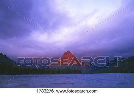 Stock Photograph - Dawn light on Mount Sinopah and Two Medicine Lake, Glacier National Park. Fotosearch