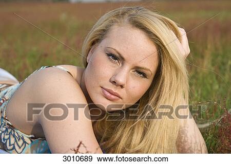 Stock Photo - A young woman lying in a meadow, close-up . Fotosearch