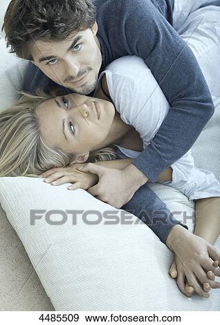 Stock Photo - Affectionate young couple lying in bed . Fotosearch