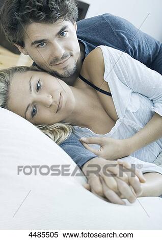 Affectionate young couple lying in bed  View Large Photo Image Stock Photography - Affectionate young couple lying in bed . Fotosearch