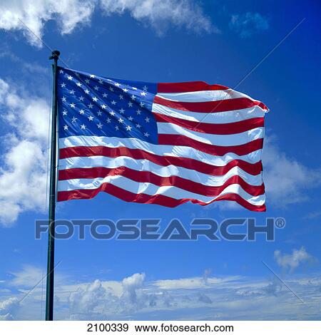 Stock Photo - American flag fluttering against cloudy sky, USA . Fotosearch