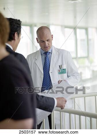 Stock Photo - Architect discussing blueprint with doctor . Fotosearch