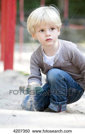 Stock Image - Blond boy playing on playground . Fotosearch