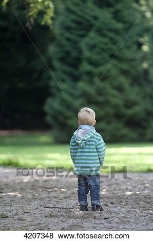 Blond boy standing in forest, back view View Large Photo Image Stock Photo - Blond boy standing in forest, back view . Fotosearch