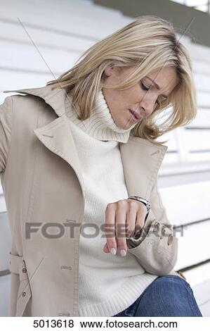 Blond woman checking the time View Large Photo Image Stock Photo - Blond woman checking the time . Fotosearch