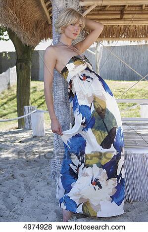 Stock Photo - Blond woman wearing elegant dress with floral pattern . Fotosearch