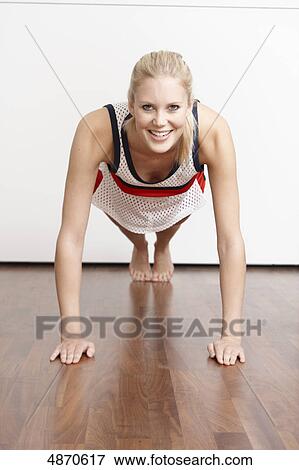 Stock Photo - Blond young woman doing push-ups . Fotosearch