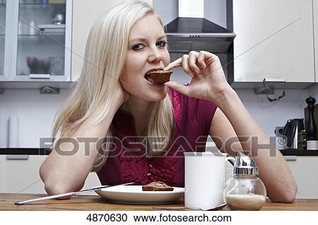Blond young woman eating pastry View Large Photo Image Stock Image - Blond young woman eating pastry . Fotosearch