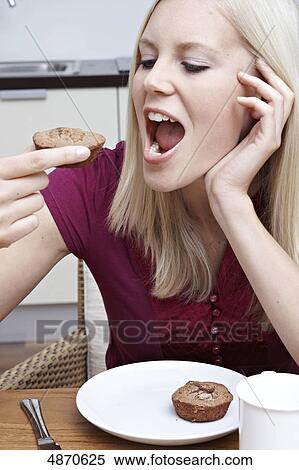 Blond young woman eating pastry View Large Photo Image Stock Photography - Blond young woman eating pastry . Fotosearch