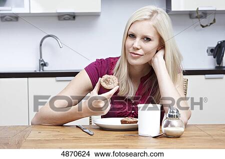 Blond young woman holding pastry View Large Photo Image Picture - Blond young woman holding pastry . Fotosearch