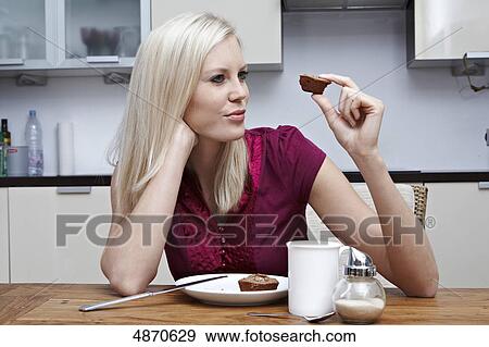 Blond young woman looking at pastry View Large Photo Image Stock Photo - Blond young woman looking at pastry . Fotosearch
