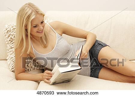 Blond young woman reading book on couch View Large Photo Image Stock Image - Blond young woman reading book on couch . Fotosearch