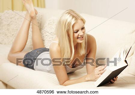 Blond young woman reading book on couch View Large Photo Image Stock Photograph - Blond young woman reading book on couch . Fotosearch
