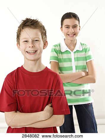 Boy and his sister standing with their arms crossed and smiling View Large Photo Image Stock Image - Boy and his sister standing with their arms crossed and smiling . Fotosearch