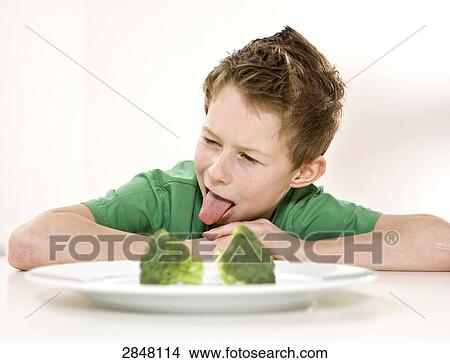 Boy disliking broccoli View Large Photo Image Picture - Boy disliking broccoli . Fotosearch