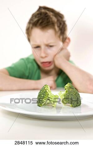 Boy disliking broccoli View Large Photo Image Stock Photography - Boy disliking broccoli . Fotosearch