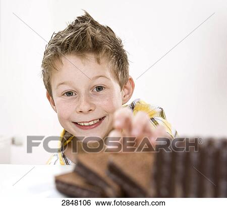 Boy having chocolate pastry View Large Photo Image Stock Photograph - Boy having chocolate pastry . Fotosearch