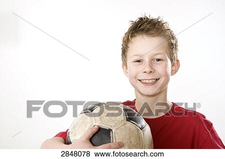 Boy holding soccer ball and smiling  View Large Photo Image Stock Photo - Boy holding soccer ball and smiling . Fotosearch