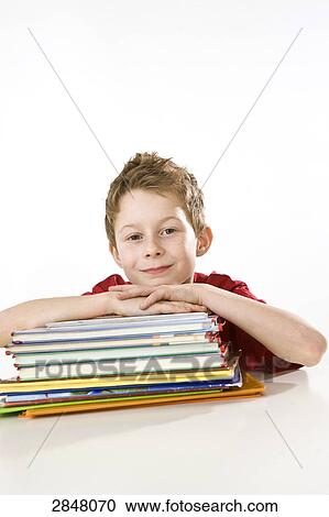 Boy leaning on books and smiling View Large Photo Image Stock Image - Boy leaning on books and smiling . Fotosearch