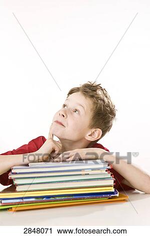 Boy leaning on books and thinking View Large Photo Image Stock Image - Boy leaning on books and thinking . Fotosearch