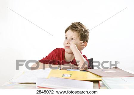 Stock Image - Boy leaning on books and thinking . Fotosearch