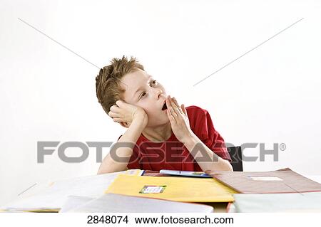 Boy leaning on books and yawning View Large Photo Image Picture - Boy leaning on books and yawning . Fotosearch