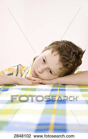 Boy leaning on table and thinking View Large Photo Image Stock Image - Boy leaning on table and thinking . Fotosearch