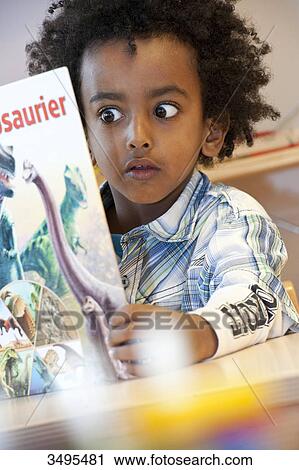 Boy looking at picture book View Large Photo Image Stock Image - Boy looking at picture book . Fotosearch