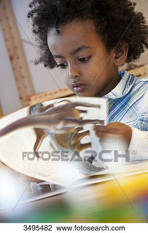 Boy looking at picture book View Large Photo Image Stock Image - Boy looking at picture book . Fotosearch