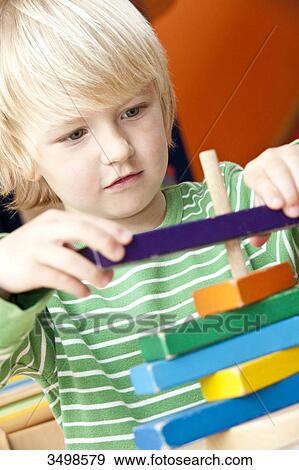 Stock Photo - Boy playing with building blocks, low angle view . Fotosearch