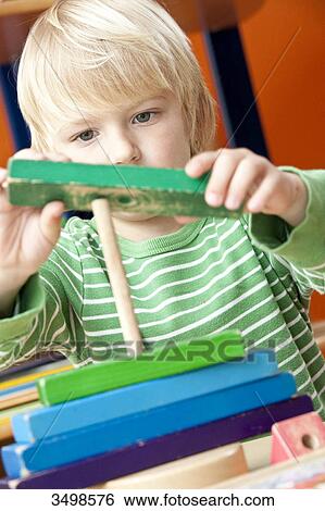Boy playing with building blocks, low angle view View Large Photo Image Stock Photograph - Boy playing with building blocks, low angle view . Fotosearch