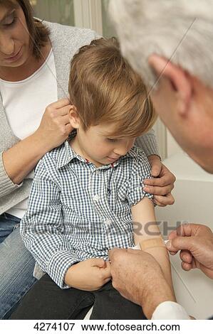 Stock Photo - Boy with mother at the doctor . Fotosearch
