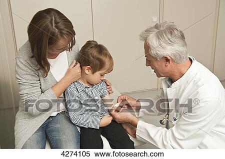 Stock Photography - Boy with mother at the doctor . Fotosearch