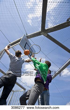 Boys playing basketball, low angle view View Large Photo Image Stock Photo - Boys playing basketball, low angle view . Fotosearch