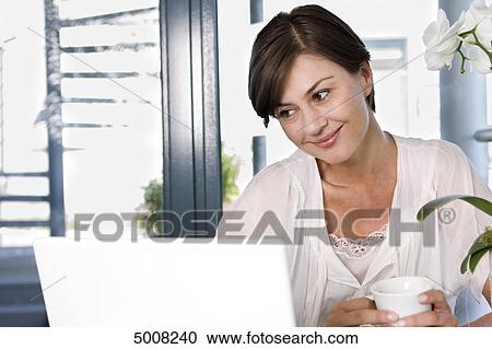 Brunette woman with laptop and cup of coffee View Large Photo Image Stock Image - Brunette woman with laptop and cup of coffee . Fotosearch