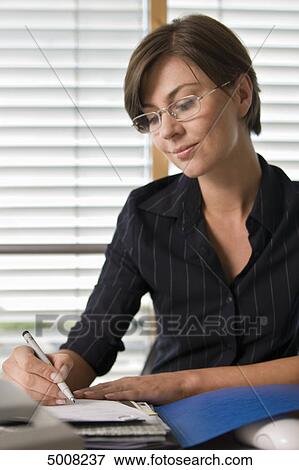 Stock Photo - Brunette woman working at desk . Fotosearch