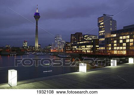 Buildings lit up at dusk View Large Photo Image Stock Photo - Buildings lit up at dusk . Fotosearch