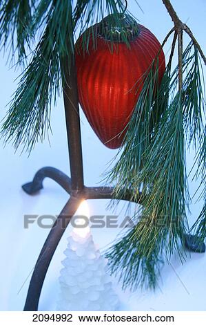 Stock Image - Burning candle under Christmas tree . Fotosearch