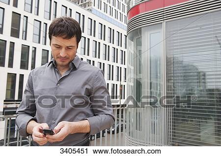 Stock Image - Business man reading sms . Fotosearch